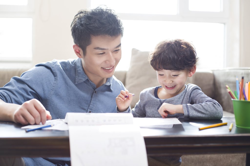 Young father helping son with homework